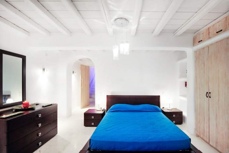 A piece of fun, colorful artwork hangs above the bed, adding vibrant color to the space. Luxury Spacious Family Summer House In Mykonos Kids Love Greece